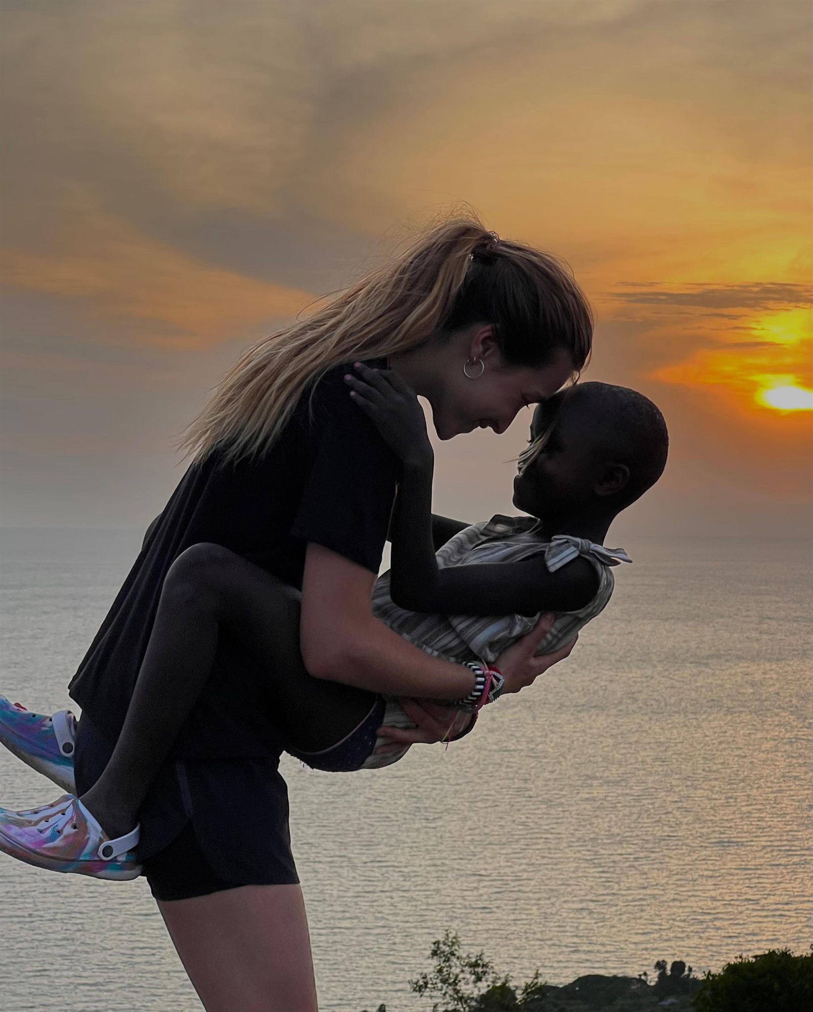 Fundadora de 6º Studio abrazando a un niño al atardecer en un proyecto de Asociación Arena en Kenia